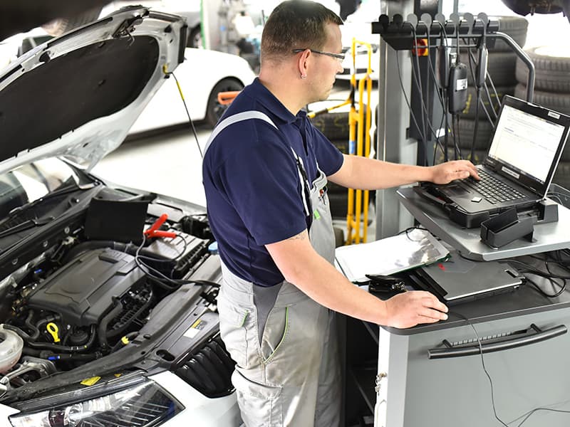 Mechaniker in der Autowerkstatt in Lübeck beim Softwareupdate mit einem Diagnosecomputer