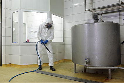Arbeiter reinigt Fußboden mit Hochdruckreiniger