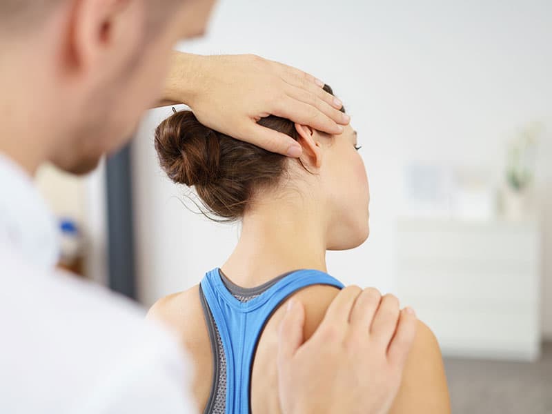 Physiotherapeut in Lübeck behandelt eine Patientin mit Nackenschmerzen